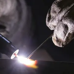 Un soldador usa una antorcha para crear una chispa brillante, demostrando que es la soldadura.